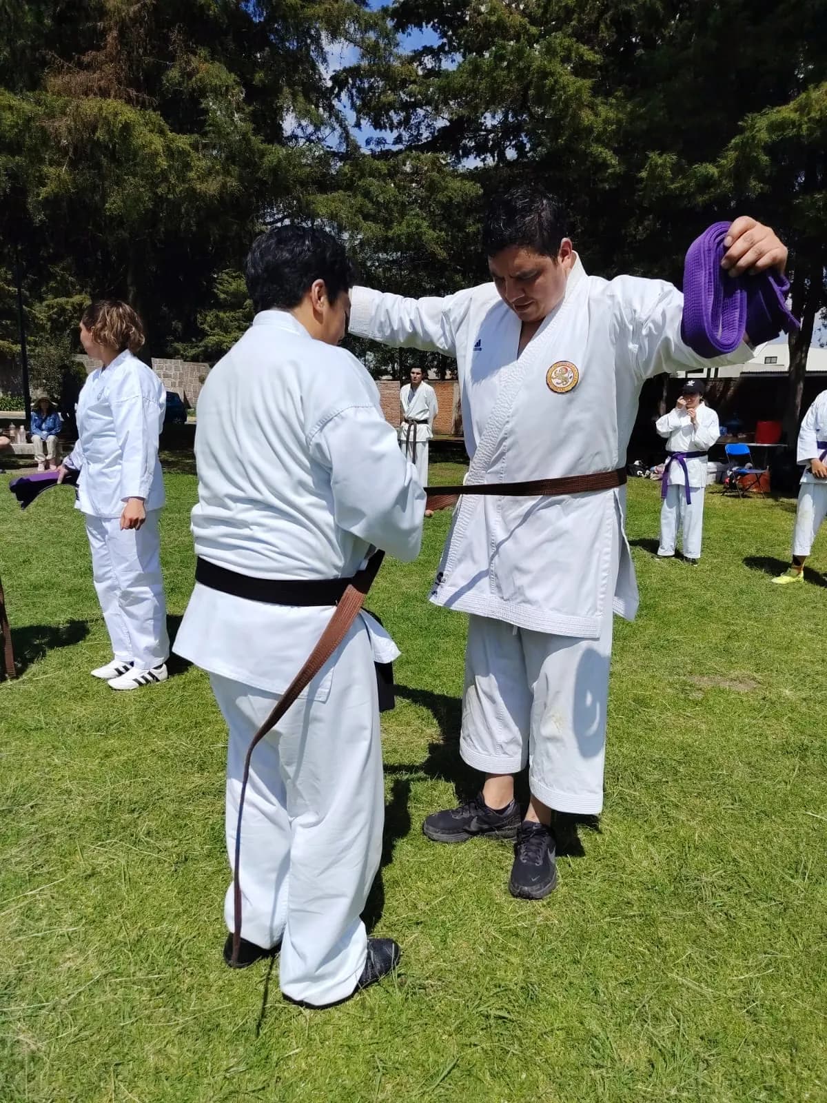 Sensei coloca la cinta morada a un alumno